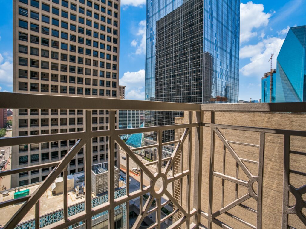 Rooftop view of downtown Dallas through the railing of a private patio.