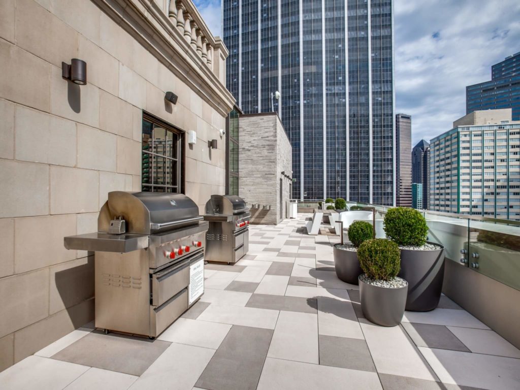 Outdoor grills on rooftop patio with limited seating and downtown views
